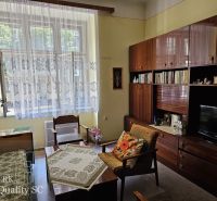 Living room in a two-room apartment with retro furniture and a large window.