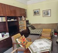 Living room in a two-room apartment with retro furniture and decorative elements.