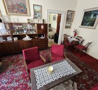 Living room in a two-room apartment with a red carpet and a wooden wall unit.