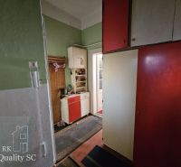 Interior of a 2-room apartment with a colorful kitchen unit and a telephone on the wall.