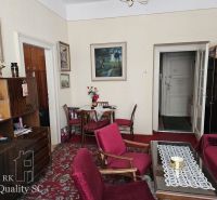 Living room in a two-room apartment with a red carpet and wooden furniture.
