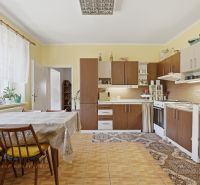 A kitchen in a family house with classic furnishings, a wooden decor floor, and a dining table.
