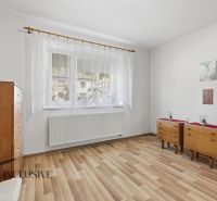 A room in a family house with a wooden decor floor, furniture, and white curtains.