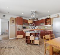 A kitchen with a wooden decor floor, wooden furniture, and appliances in a family house.