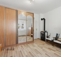 A room in a family house with a fireplace, a wardrobe, and a floor with a wooden decor.