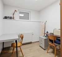 A study room in a family house with a wooden decor floor, tables, and chairs.