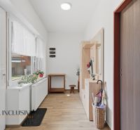 Hallway of a family house with a wooden decor floor, bright entrance hall with furniture.