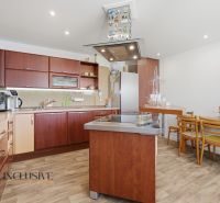 A kitchen in a family house with a wooden decor floor and wooden furniture.