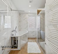 A bathroom with a bathtub and a wooden decor floor in a family house, bright interior.