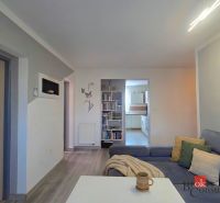 Living room with wooden floor decor and comfortable seating in a 4-room apartment.