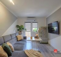 Living room in a 4-room apartment with a comfortable sofa and a TV on the wall.