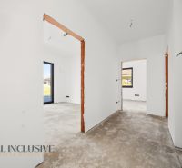 Unplastered interior walls and rough floor, rooms with a view outside. Family house.