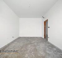 Empty room with a concrete floor and white walls in a family house.