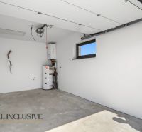 A garage in a family house with a concrete floor and white walls.