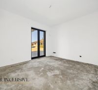 A room with white walls and a large window in a family house.