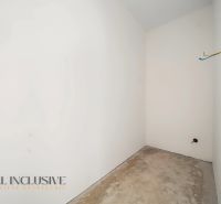 Empty room with white walls and a raw floor in a family house.