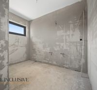 Unfinished room in a family house with smooth walls and a window.