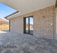 Outdoor terrace of a family house in Hviezdoslavov with a brick wall and paving.