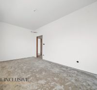 An empty room in a family house without flooring, white walls, construction phase.