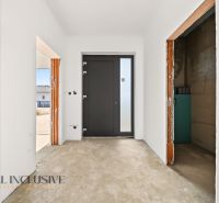 Entrance area in a family house with white walls and dark doors.