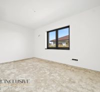 An unfurnished room with white walls and a large window in a family house.