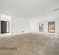 Interior of a family house with a concrete floor and large windows.