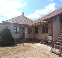 A family house in Bánov with a metal staircase and a fenced garden.