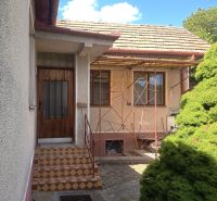 A family house in Bánov with a staircase leading to wooden doors on the property.