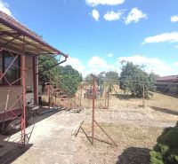 A family house in Bánov with an external staircase and a yard with fruit trees.