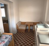 A kitchen in a family house with seating and checkered flooring.