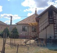 A family house in Bánov with an external staircase, a sloped roof, and a garden.