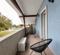 A balcony with black chairs and a blue wall in a 2-room apartment in Horný Bar.