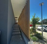 Entrance via stairs with wooden railing on Gen. Golián Street, Trnava.