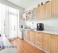 A kitchen with a wooden decor floor and appliances in a 3-room apartment.
