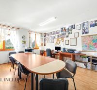 Office of a 3-room apartment with a long table, computers, and shelves with books.
