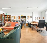 Library with comfortable seating and writing desks on a floor with wooden decor.