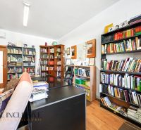 A library and a desk in a 3-room apartment with a wooden decor floor.