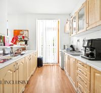 A kitchen in a 3-room apartment with a wooden decor floor and a kitchen unit.