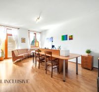 A bright living room with wood-patterned flooring, armchairs, and a desk in a 3-room apartment.