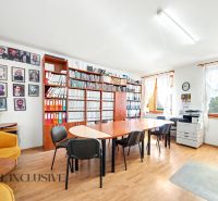 An office with a wood-patterned floor, a bookshelf, a desk, a chair, and a copier.