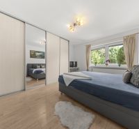 Bedroom in a family house with a wardrobe and a wooden decor floor.