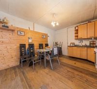 A kitchen in a family house with wooden paneling and a floor with a wooden decor.
