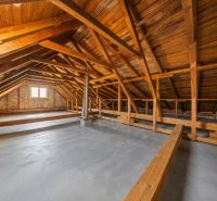 Attic space in a family house with wooden beams and brick walls.