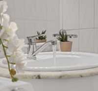 A sink with running water and decoration in a family house.