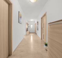 A hallway in a family house with a wooden decor floor and built-in furniture.