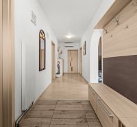 Interior of a family house with a hallway, mirror, and wooden decor flooring.