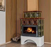 Tiled stove in the interior of a family house with a wooden decor floor.