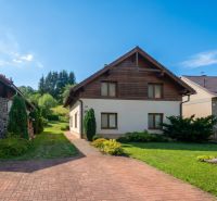 A family house in Horná Lehota surrounded by a garden with a lawn and a driveway.