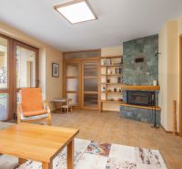 Living room in a family house with a fireplace, a shelf, and a comfortable armchair.