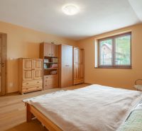 A bedroom in a family house with a wooden decor floor and wooden furniture.